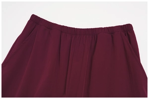 Detail of burgundy sports pants featuring elastic waistband and invisible side pockets
