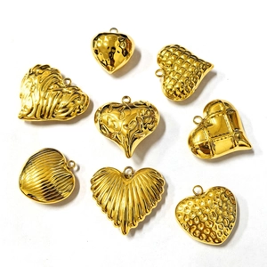 Macro view of eight assorted gold stainless steel heart pendants with various textures