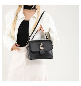 Detail of black leather texture and gold metal buckle on a shoulder bag for women