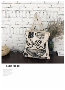 Dettaglio della borsa tote in tela bianco avorio con stampe di frutta e piante a mano