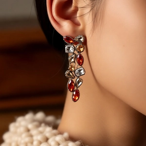 Detailed close-up of vintage drop earrings featuring red and clear rhinestones