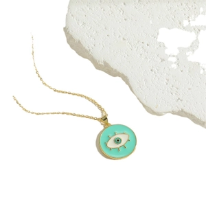 Gold chain necklace featuring a round mint green evil eye pendant on white marble