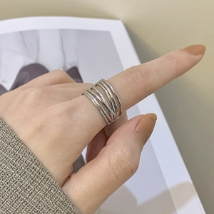 Detail shot of multi-layer silver open ring worn on finger in a stylish lifestyle setting