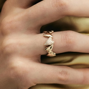 18k gold plated heart-shaped zircon ring on yellow silk fabric background