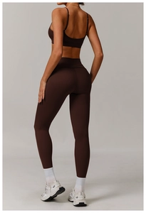 Detail of dark brown open-back sports bra and high-waist leggings on a model