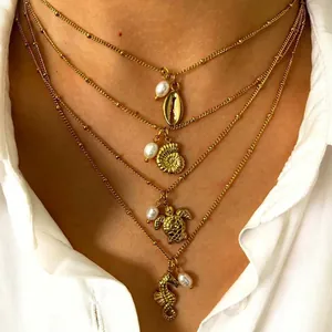 Detailed layered gold necklace with seashell, sea turtle, and seahorse charms and pearls
