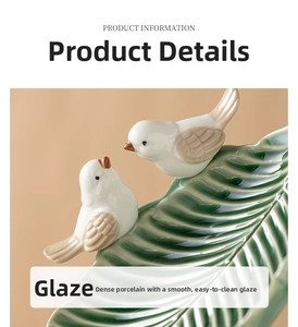 Macro view of green ceramic leaf tray featuring detailed white porcelain birds