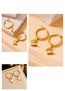 Detailed macro view of gold-plated butterfly pendant hoop earrings with textured finish