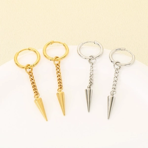 Detail of silver and gold punk cone chain earrings displayed on a white round platform