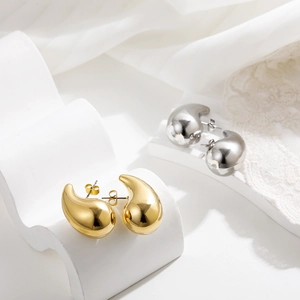 Close-up of elegant gold and silver teardrop earrings with smooth metallic finish