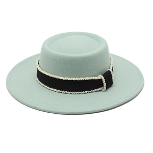 Detail of mint green wool felt boater hat with black ribbon and pearl bead accents