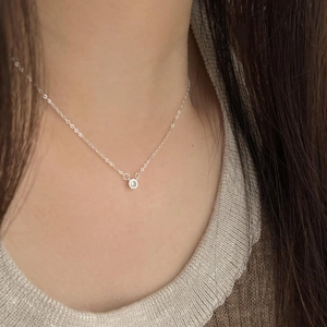 Macro shot of minimalist 925 silver necklace with single round cubic zirconia pendant