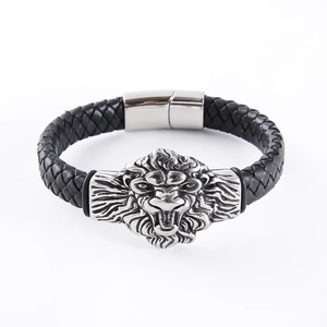 Detail of black braided leather bracelet featuring a silver lion head charm and magnetic clasp