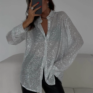 Détail d'une chemise argentée à paillettes à manches longues avec tissu scintillant chic