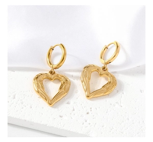 Vue macro de boucles d'oreilles cœur en acier doré à l'or 18 carats sur pierre