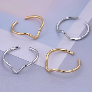 Dettaglio di anelli regolabili ondulati minimalisti in acciaio inossidabile oro e argento