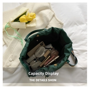Detail view of the green quilted tote bag showing large capacity storage and magnetic closure