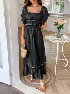 Détail de la robe d'été noire avec des finitions à volants blancs et une encolure carrée
