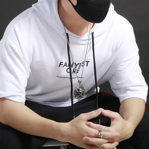 Detailed view of punk style pirate skull pendant on male model with dark metal finish