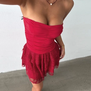 Close-up of red strapless dress featuring ruffled bodice and layered lace patchwork details