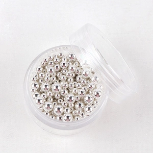 Vista macro di microsfere d'argento per nail art in varie misure in custodia rotonda
