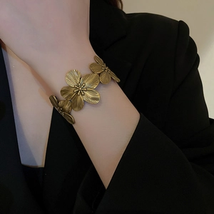 Detailed macro view of vintage bronze flower cuff bracelet with brushed metal texture