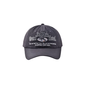 Detail of high-density white dolphin hotel embroidery on charcoal grey washed cotton cap