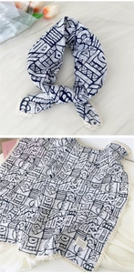 Detail of blue and white geometric scarf with delicate lace trim and tulip prop