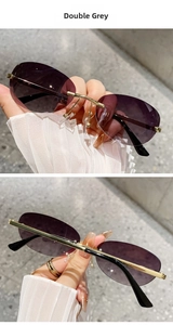 Detail of rimless sunglasses with double grey gradient lenses and gold metal frames