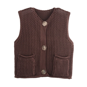 Detail of dark brown crochet knit vest showing retro metal buttons and textured pockets