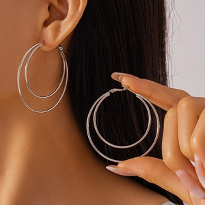 Silver double layered geometric round hoop earrings shown on model and hand
