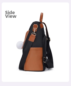 Side view of waterproof black and brown leather backpack with side pocket and pom pom detail