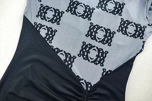 Detail of ruched grey fabric with abstract print and black stitching on a slim dress
