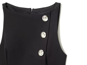 Detail view of black sleeveless top with three crystal rhinestone buttons on the shoulder