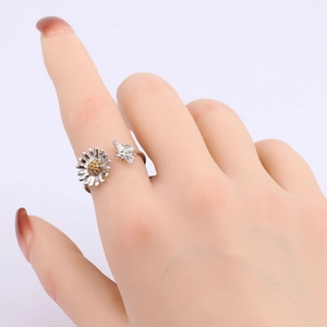 Close-up of s925 silver sunflower and bee open ring on a purple background