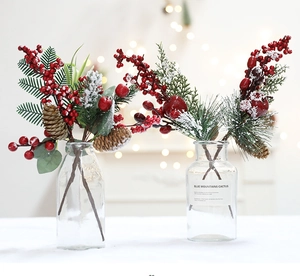 Detail of Christmas table decor with red berries, pine cones and cedar branches in glass vase