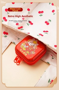 Close-up of a festive red tin coin purse with a cartoon ox and double zipper design