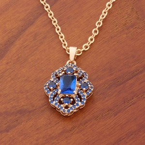 Luxurious gold-plated necklace featuring a blue zircon rhombus pendant on a wooden background