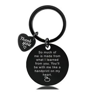 Detail of matte black teacher gift keychain with engraved apple and thank you heart pendant