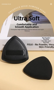 Detail view of two soft triangular black powder puffs for makeup application and setting