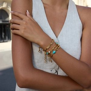 Layered gold titanium steel bracelet with turquoise beads and pearls on female wrist