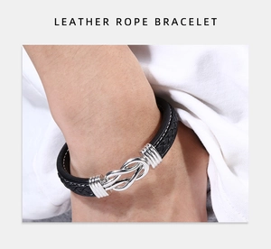 Gros plan d'un bracelet en cuir tressé noir avec boucle à nœud argenté et anneaux
