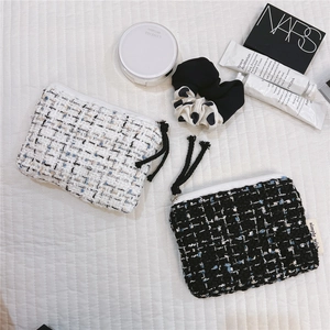 Detail of tweed mini coin pouches in black and white with soft zipper cotton rope pullers