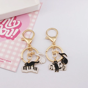 Artistic piano cat keychains with music notes and gold metal enamel finish for bags
