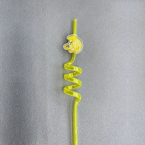 Macro shot of yellow spiral reusable straw with sparkling glitter charm decoration
