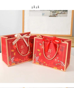 Detail of red wedding gift bags with silk handles and gold floral motifs