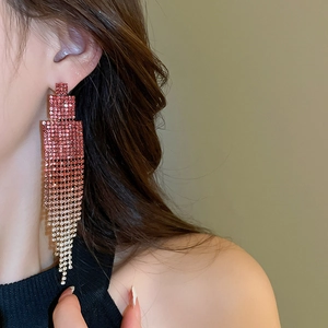 Detailed close-up of geometric tassel earrings with gradient rhinestones on silver needles