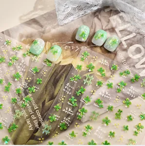 Detail view of lucky green clover nail stickers with stars and grid patterns on white lace