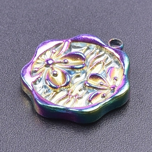 Macro shot of 18k rainbow plated clover flower pendant with butterfly relief detail