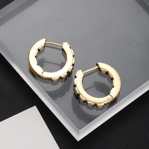Macro shot of 18K gold plated huggie earrings featuring channel-set white zircons
